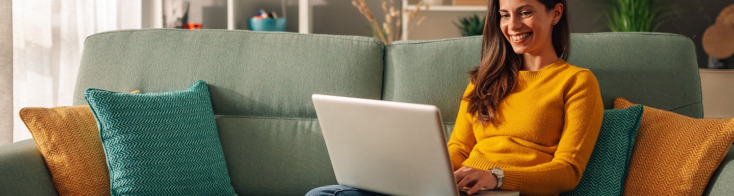 Instructor grading on a couch with their laptop