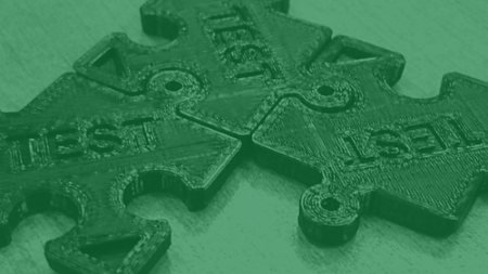 Three 3D printed puzzle peaces labeled "Test"