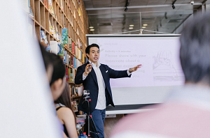 Professor standing in front of a white board teaching a class